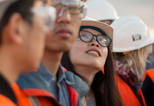 Girl looking up in construction vest and hardhat