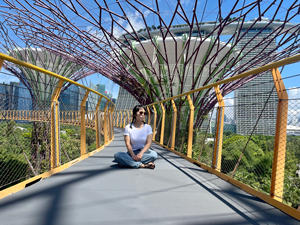 Woman sitting on a bridge with sunglasses on.