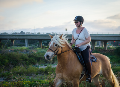 A woman riding a horse in a field.