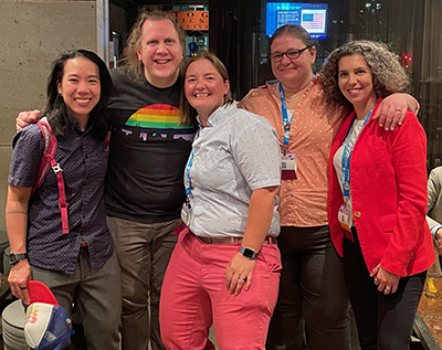 Group photo of five people smiling with their arms around each other, with Matsushita at left.