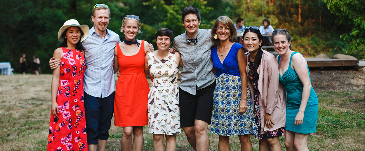 A group photo of eight people outside at a wedding.