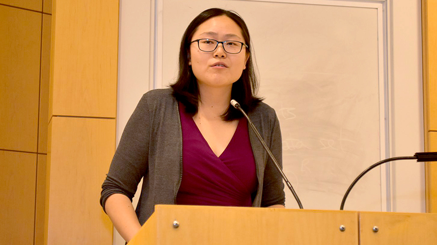 Connie Tzou speaking at a podium during the DEOHS graduation ceremony.