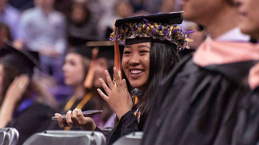 Student sits waiting for to graduate in the SPH graduation ceremony.