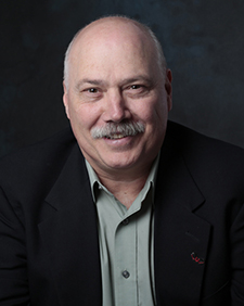 Headshot of Micheal Yost on a dark background