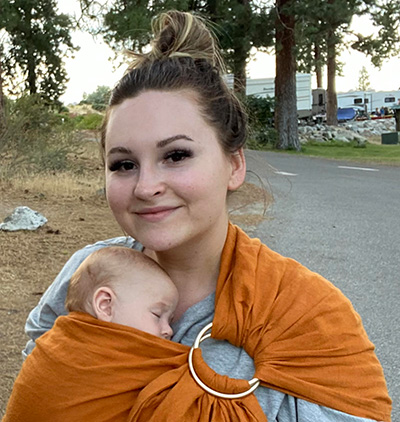 Antonchuk outside with her baby in a sling.