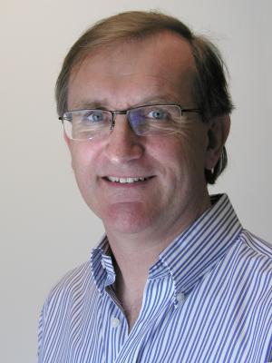 Headshot of Toby Cole, an older white man with brown hair and glasses