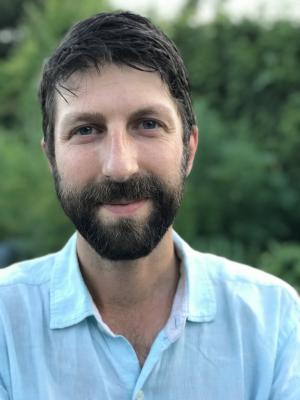 Dr Bardosh, a young white man with dark brown hair and a beard