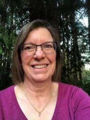 Headshot of Elizabeth Dykstra, a middle-aged white woman with glasses and short brown hair