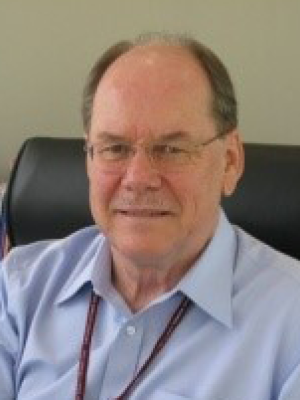 Headshot of Dr Hoff, an older, bespectacled balding white man with salt and pepper hair and a mustache