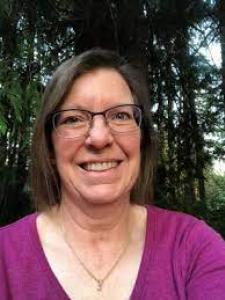 Headshot of Elizabeth Dykstra, a middle-aged white woman with glasses and short brown hair