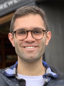 A middle-aged white man with short brown hair and tortoiseshell glasses