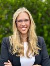 Lady with blonde hair and clear glasses smiling