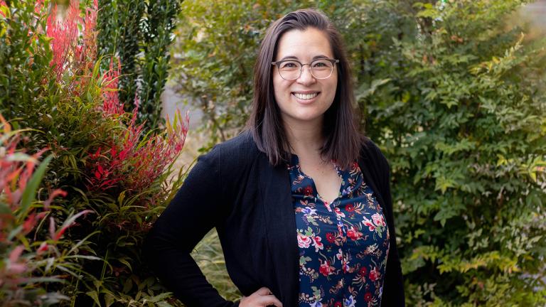 Photo of Shelley Stephan smiling outside with plants in the background.