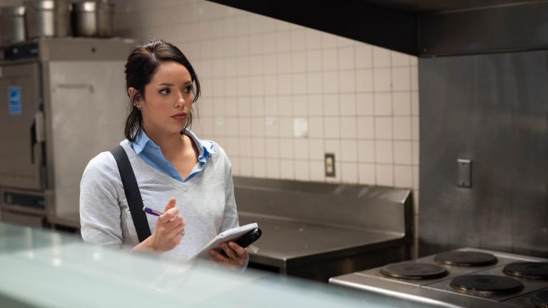 Marissa working in a cafeteria taking food safety notes