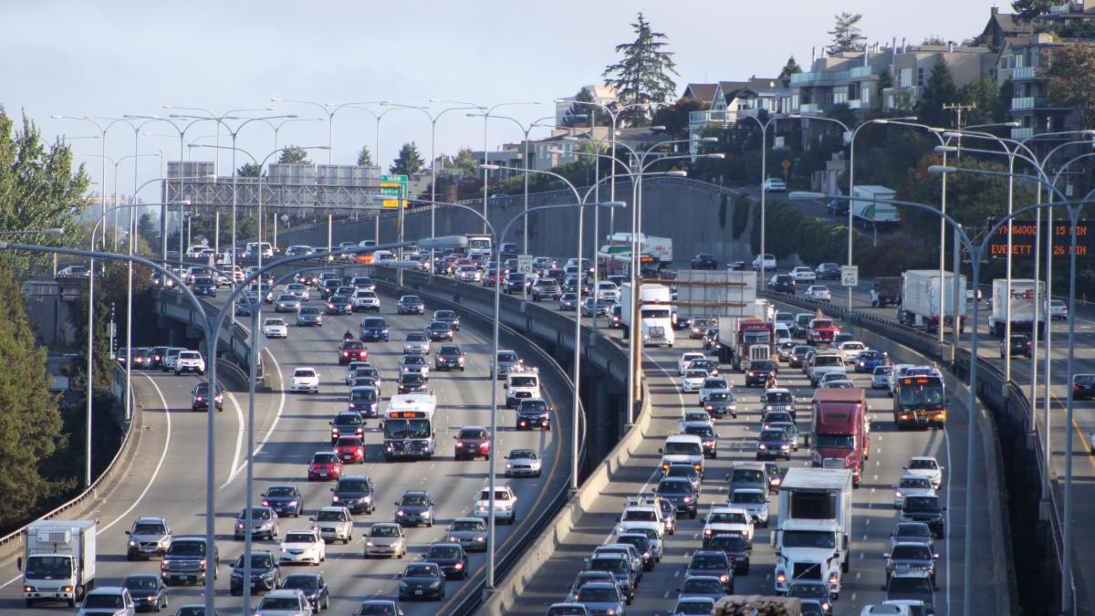 Heavy traffic on highway I-5 in Seattle with houses on a ridge above.