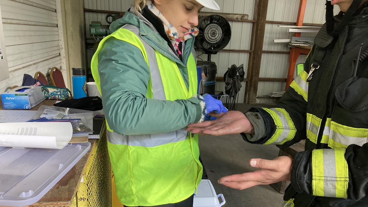 DEOHS MS student Asheton Gilbertson swabs a firefighter's hands for chemical analysis.