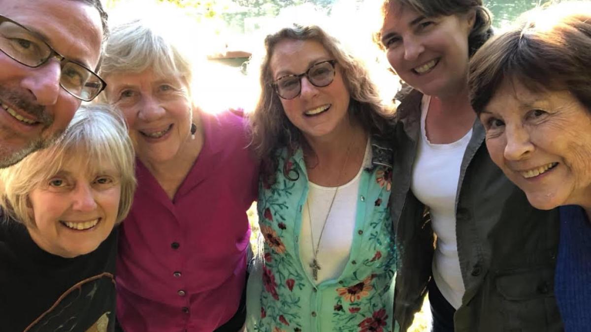 Sharon Morris stands with five other people with their arms interlocking.