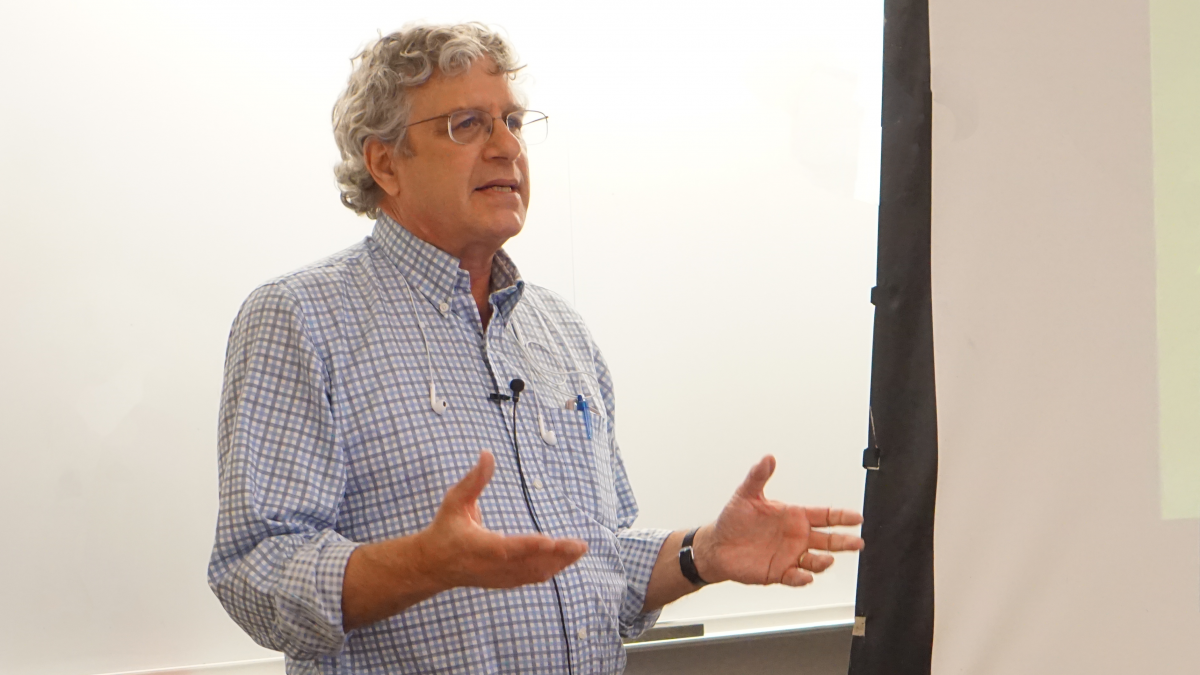 Rosenfeld teaching a class with his arms outstretched.