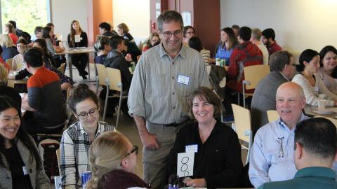 People talking around a table at the DEOHS kickoff.