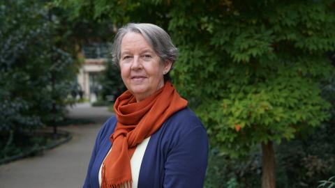 Lianne Sheppard stands on the UW campus with leafy trees in the background.