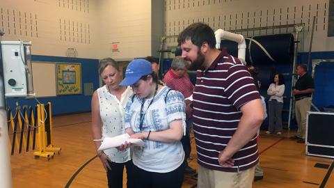 DEOHS student Silvia Rus examines data gathered during her internship as her supervisors look on. Photo courtesy of Silvia Rus.