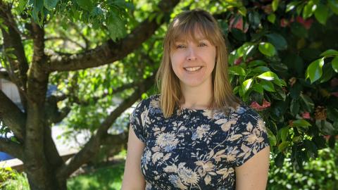 Portrait of Rebekah Petroff with a tree in the background.