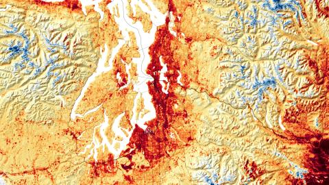 A temperature contour map of western Washington with dark red in the areas near Puget Sound, orange over the Kitsap Peninsula and lighter orange and yellow over the higher elevation with blue over the Cascade and Olympic mountain ranges.