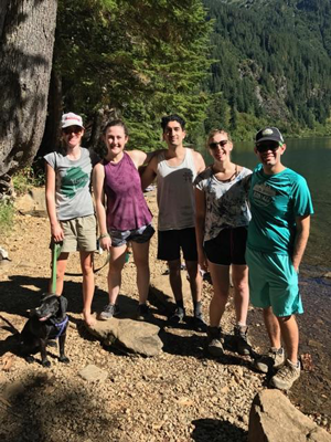 Five hikers in front of an alpine lake.