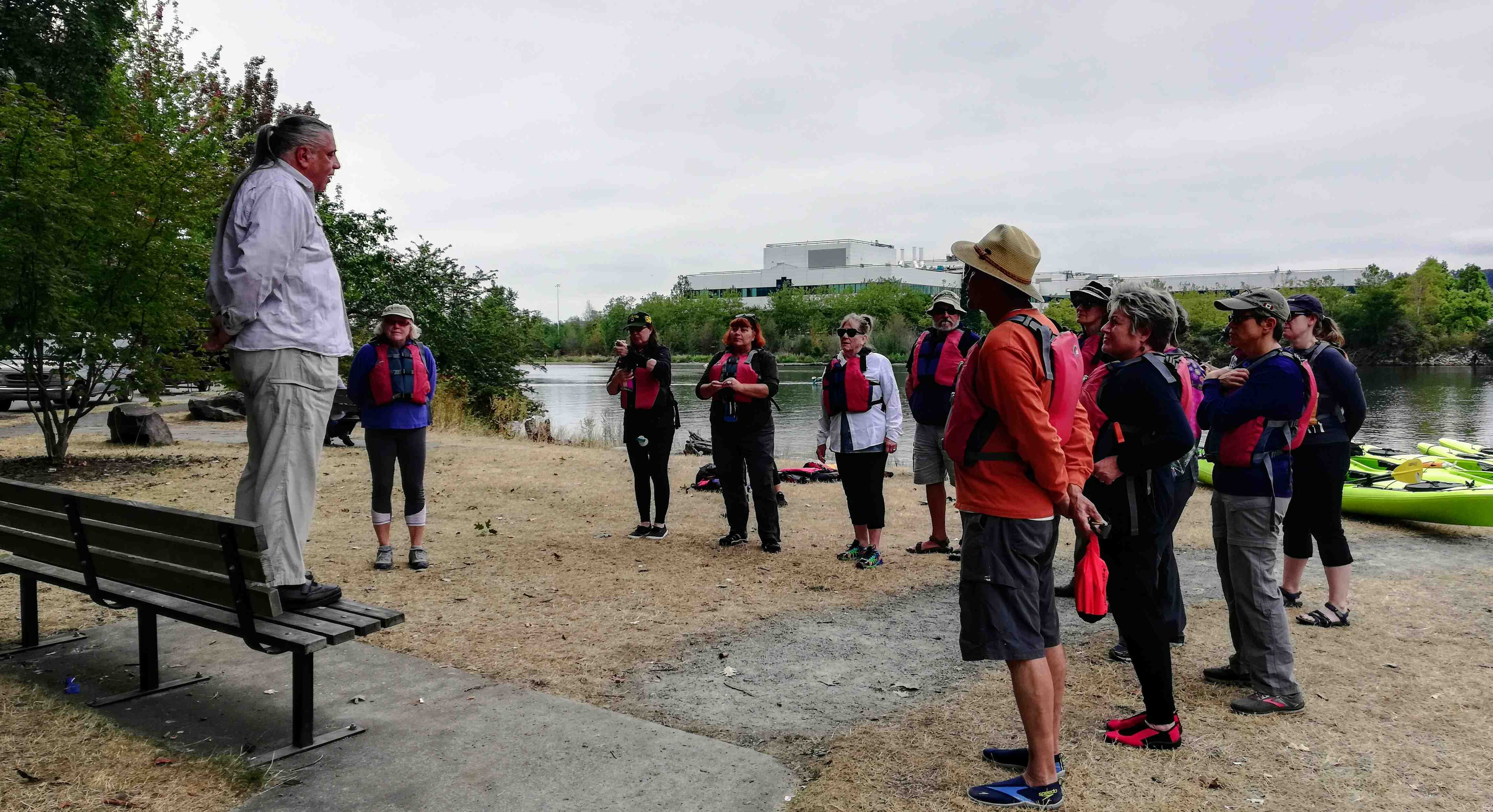 Kayakers listen to a presentation onshore